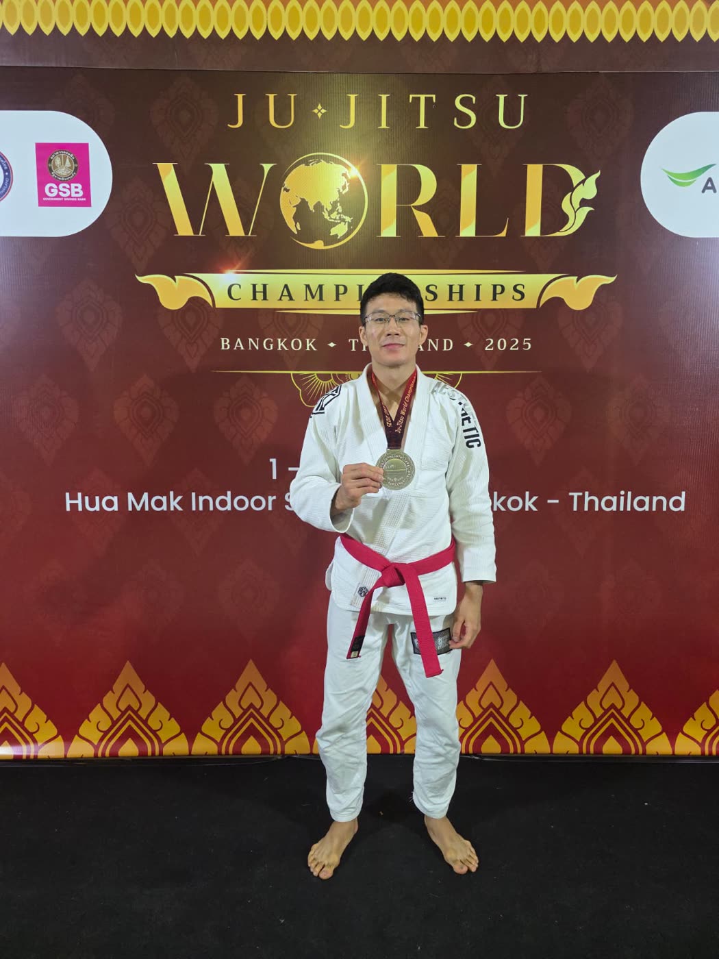 Noah Lim in a white gi holding his silver medal at the Ju-Jitsu World Championships in Bangkok